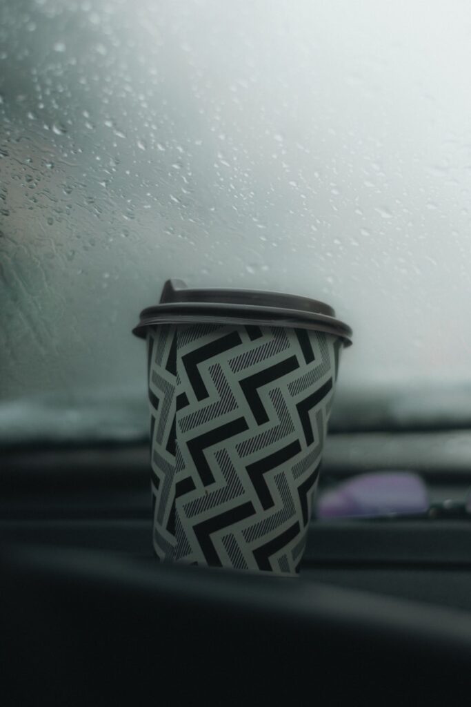 a cup of coffee sitting on the dashboard of a car