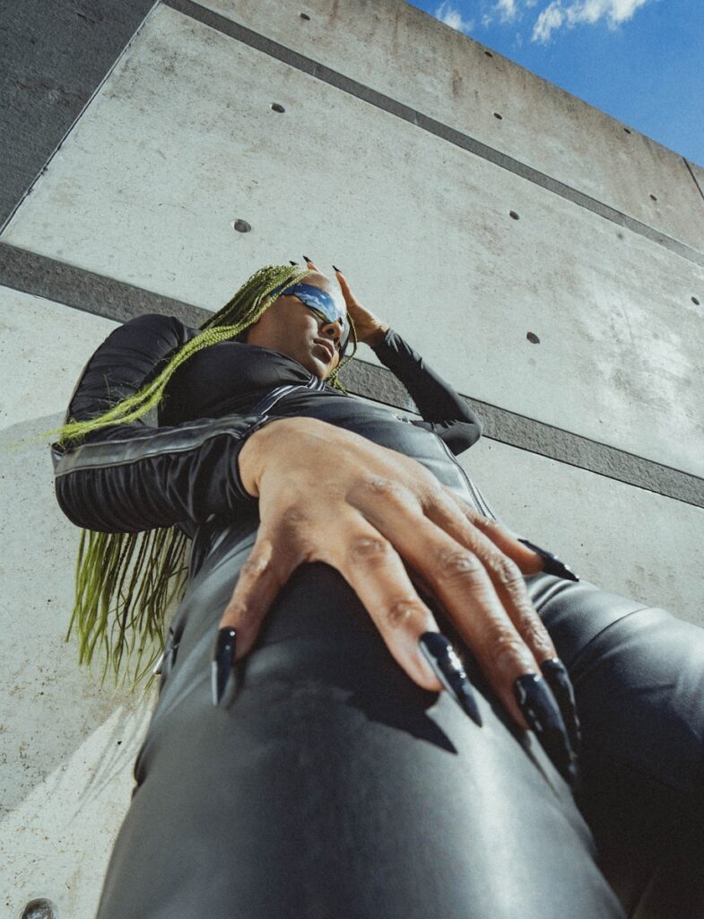 a woman in a black leather outfit with a hand on her hip