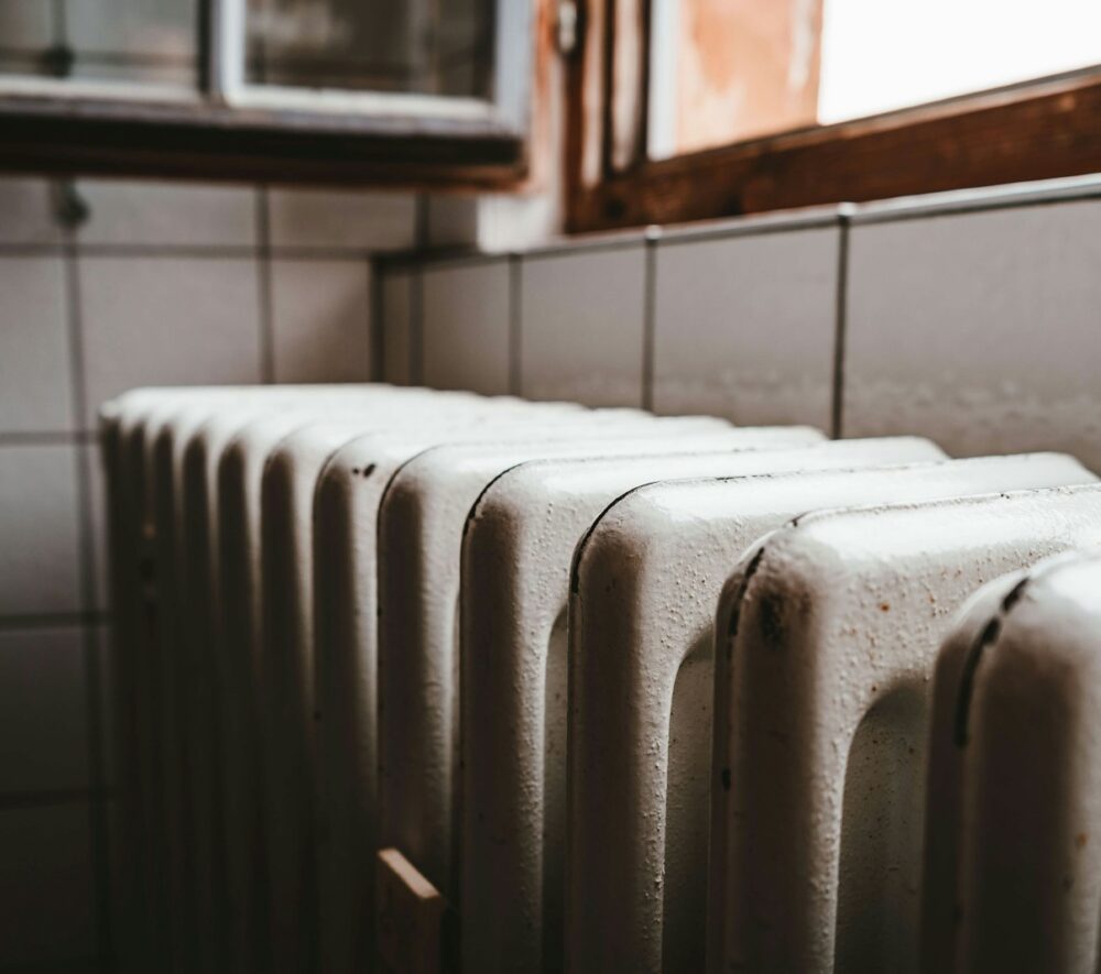 biały kaloryfer pod oknem/ fot: Julian Hochgesang/unsplash