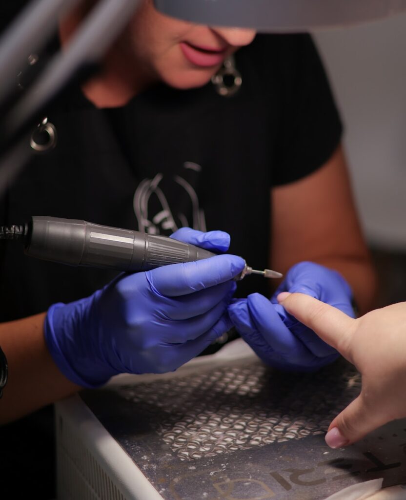 a woman getting her nails done at a nail salon