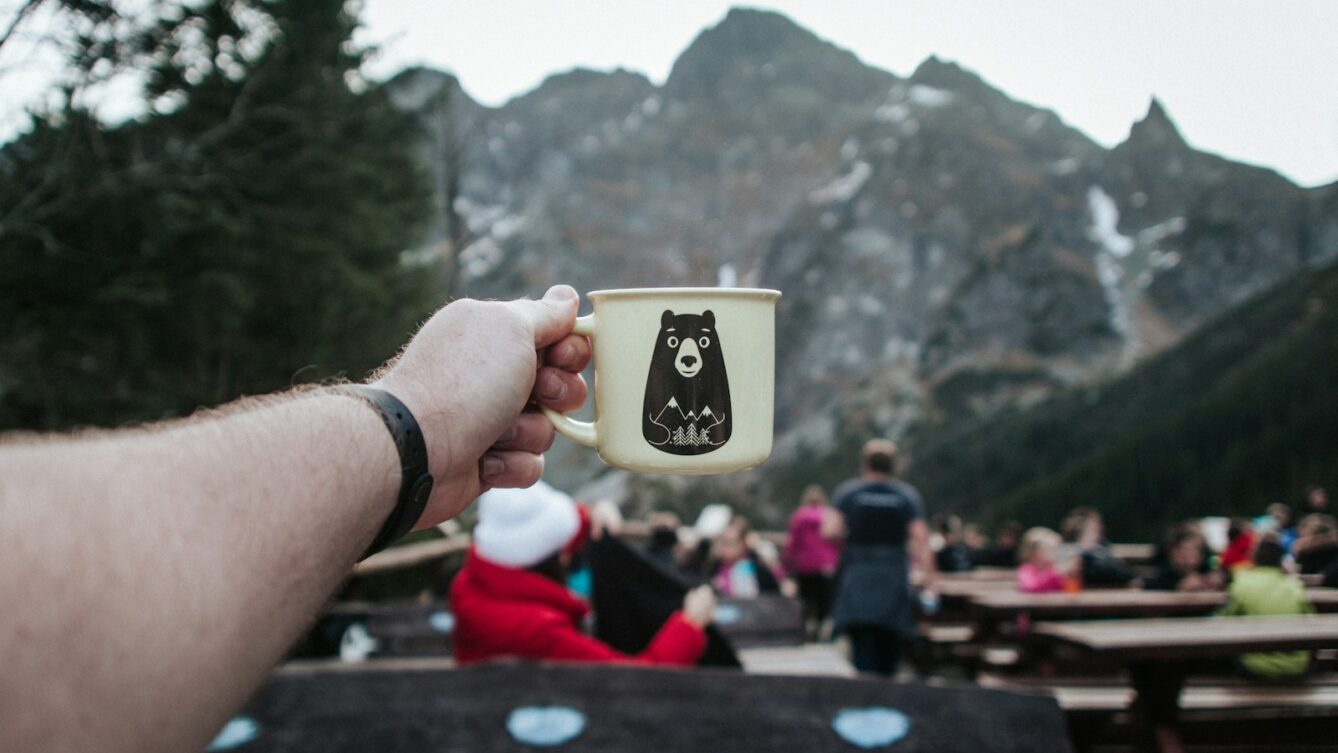 person holding white mug