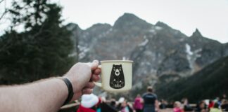 person holding white mug