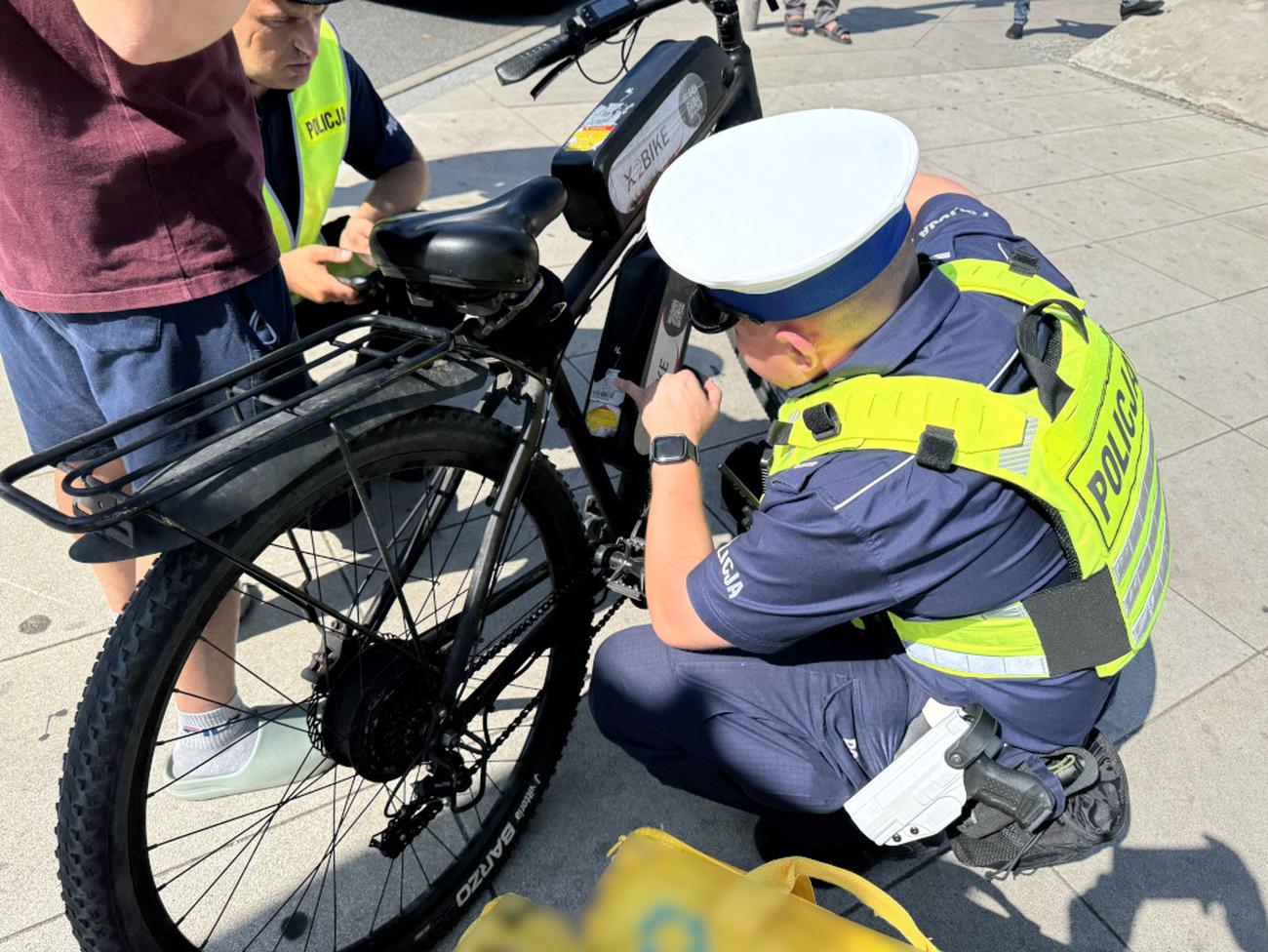 Policjant kontrolujący rower elektryczny pod kątem oznaczenia CE i zgodności z przepisami. /Policja