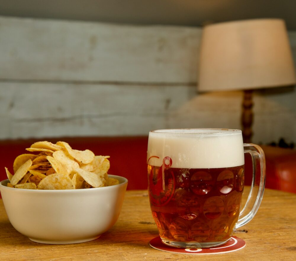 Kufel piwa i chipsy na stole/fot: Bohdan Stocek/Unsplash