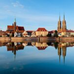 brown and white concrete building near body of water during daytime