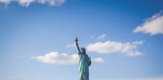 Statue of Liberty, New York under white and blue cloudy skies