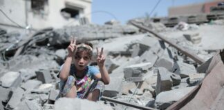 Gaza, dziecko na ruinach zbombardowanego domu