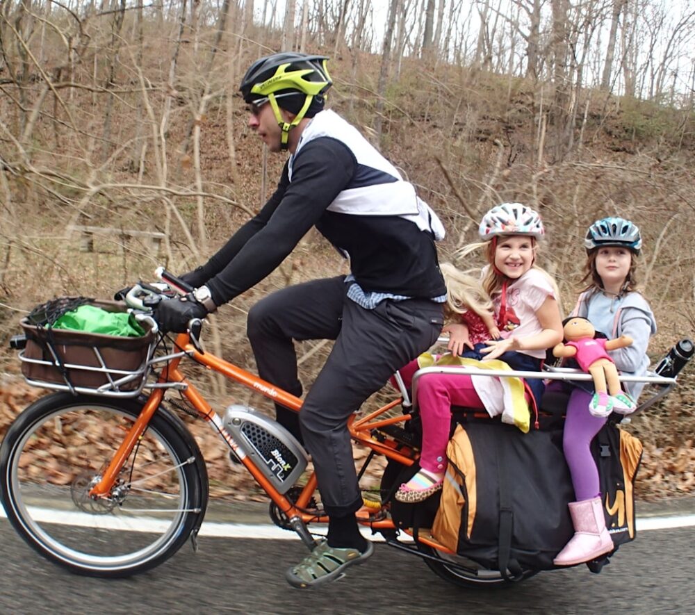 people riding on orange bicycles during daytime/ fot: Mark Stosberg/ Unsplash