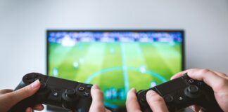 two people playing Sony PS4 game console/JESHOOTS.COM/Unsplash