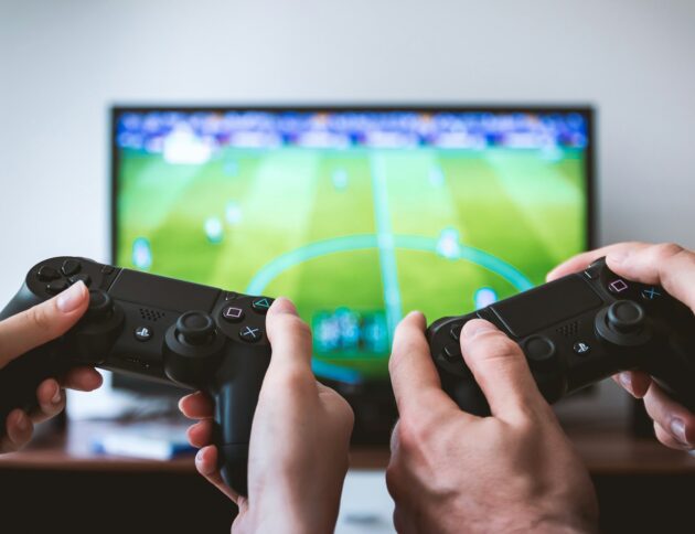 two people playing Sony PS4 game console/JESHOOTS.COM/Unsplash