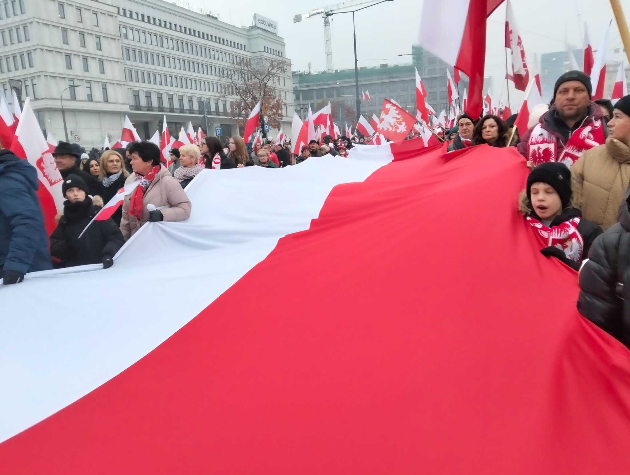 Uczestnicy Marszu Niepodległości niosący olbrzymią biało-czerwoną flagę narodową/ Autorstwa MOs810 - Praca własna, CC BY 4.0