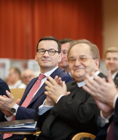 Tadeusz Rydzyk siedzący wśród polityków PiS podczas konferencji „Gospodarcza suwerenność”/ fot: KPRM, Domena publiczna