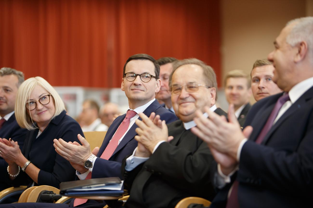 Tadeusz Rydzyk siedzący wśród polityków PiS podczas konferencji „Gospodarcza suwerenność”/ fot: KPRM, Domena publiczna