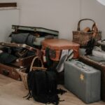 Uszkodzony bagaż po locie – sterta zniszczonych walizek w pomieszczeniu obsługi reklamacji linii lotniczych.