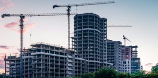 Plac budowy z powstającymi budynkami i żurawiami budowlanymi na tle miasta,fot: Anatolii Nesterov/ Unsplash