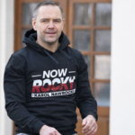 Prezydent Nawrocki reklamujący odzież rodzinnej firmy.