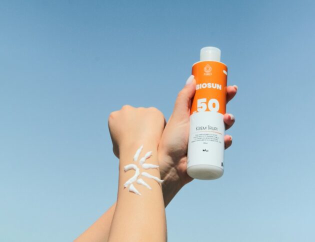 a person holding a bottle of sunscreen in their hand