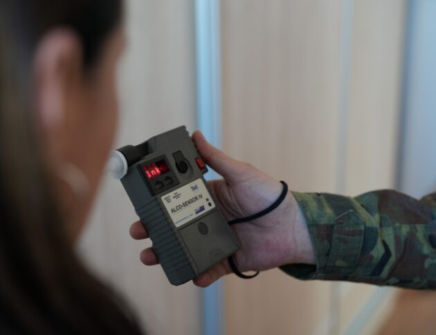 Funkcjonariusz Straży Granicznej sprawdzający trzeźwość pasażerki samolotu/ SG