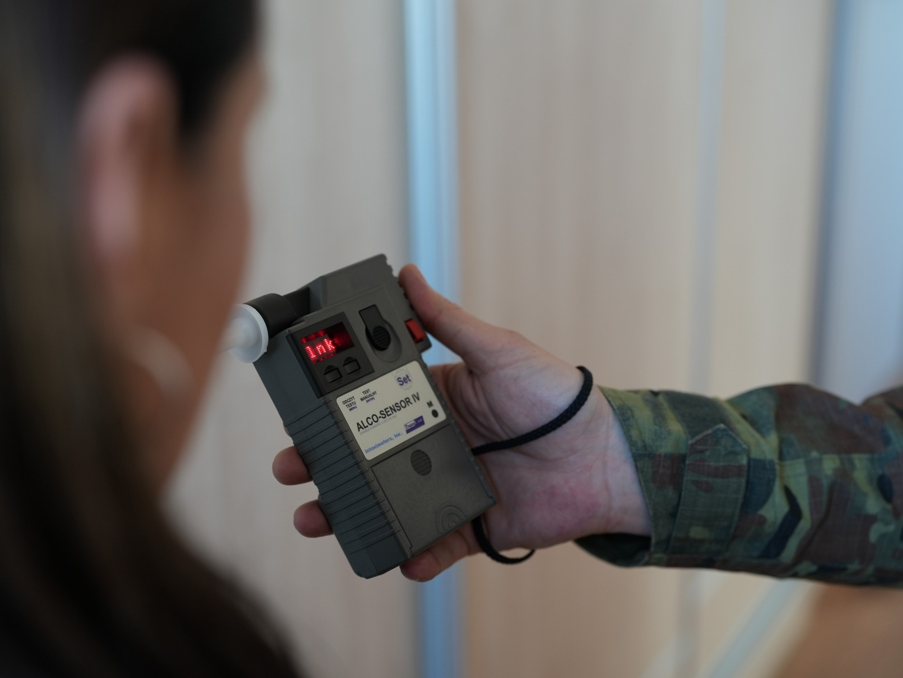 Funkcjonariusz Straży Granicznej sprawdzający trzeźwość pasażerki samolotu/ SG