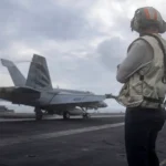 Amerykański marynarz obserwuje start myśliwca F/A-18E Super Hornet z pokładu lotniskowca USS Abraham Lincoln podczas operacji Epic Fury (23 marca 2026). Photo by NAVCENT Public Affairs