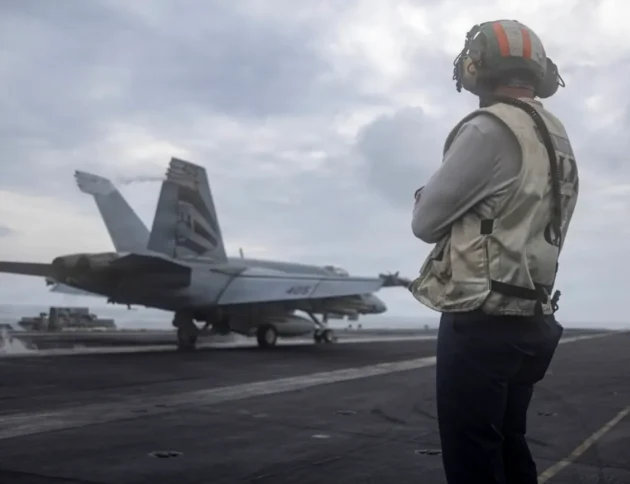 Amerykański marynarz obserwuje start myśliwca F/A-18E Super Hornet z pokładu lotniskowca USS Abraham Lincoln podczas operacji Epic Fury (23 marca 2026). Photo by NAVCENT Public Affairs