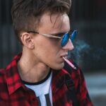 Młodzieniec palący e-papierosa. fot: Dzmitry Dudov/Unsplash