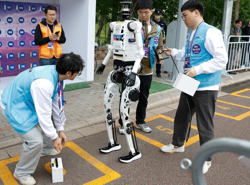 Inżynierowie wymieniają baterie w humanoidalnym robocie „Tiangong Ultra-2025” zespołu Tianyi podczas półmaratonu Beijing E-Town i półmaratonu robotów humanoidalnych w Beijing Economic-Technological Development Area, Pekin, Chiny, 19 kwietnia 2026 r. (Xinhua/Wang Lili)