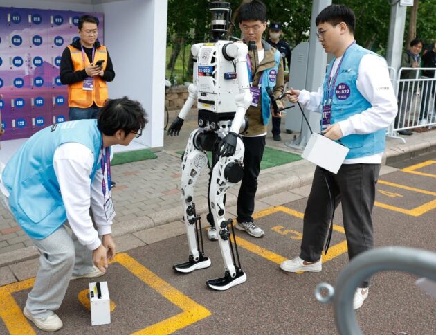 Inżynierowie wymieniają baterie w humanoidalnym robocie „Tiangong Ultra-2025” zespołu Tianyi podczas półmaratonu Beijing E-Town i półmaratonu robotów humanoidalnych w Beijing Economic-Technological Development Area, Pekin, Chiny, 19 kwietnia 2026 r. (Xinhua/Wang Lili)