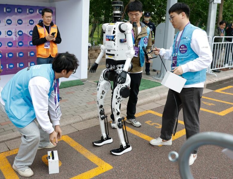 Inżynierowie wymieniają baterie w humanoidalnym robocie „Tiangong Ultra-2025” zespołu Tianyi podczas półmaratonu Beijing E-Town i półmaratonu robotów humanoidalnych w Beijing Economic-Technological Development Area, Pekin, Chiny, 19 kwietnia 2026 r. (Xinhua/Wang Lili)