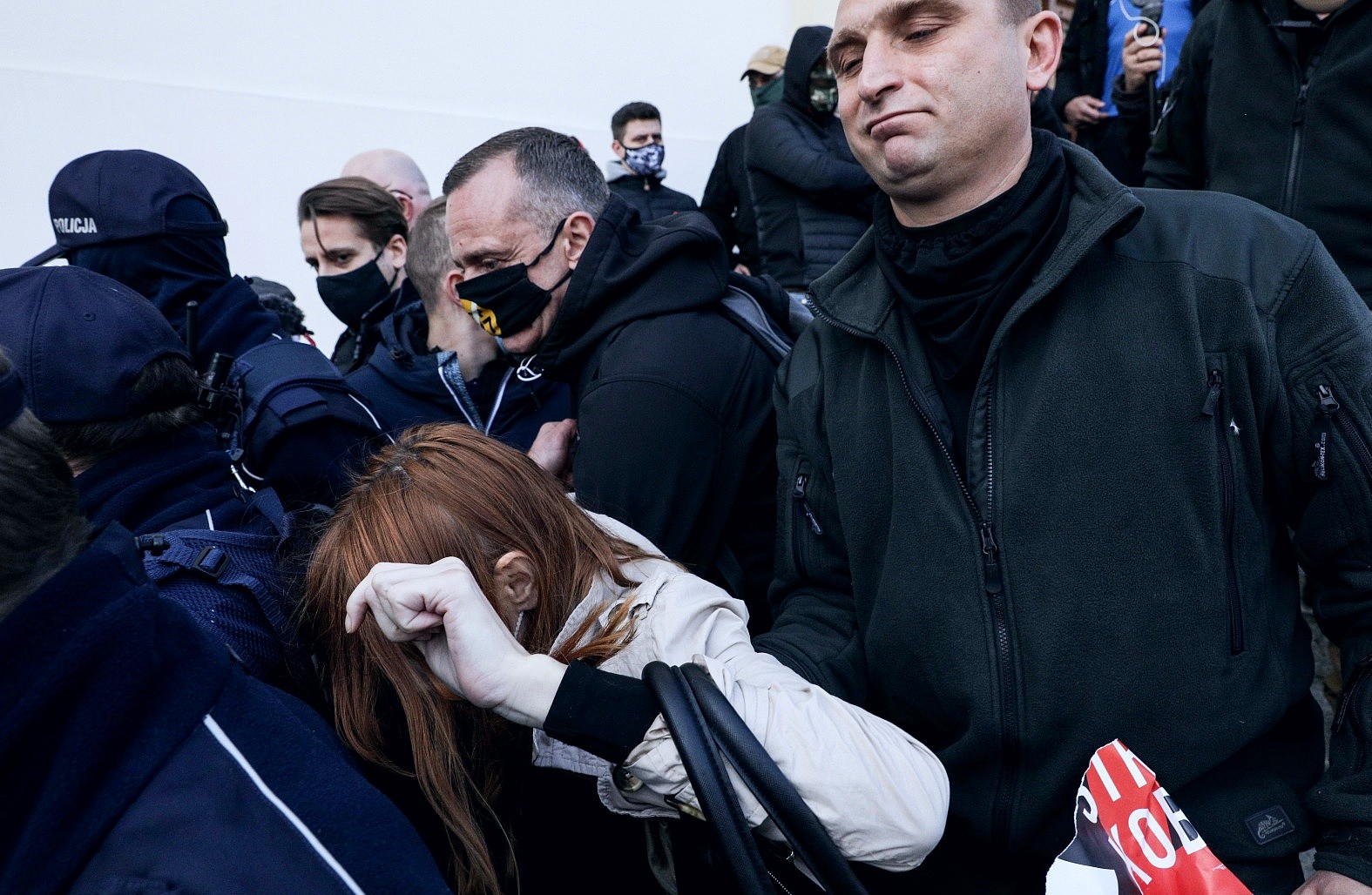 Ośrodek Monitorowania Zachowań Rasistowskich i Ksenofobicznych (OMZRiK), który wspiera oskarżycielkę: „Podczas protestów w Warszawie Robert Bąkiewicz i jego bojówkarze siłą wynieśli kobietę z kościoła św. Krzyża, a następnie zrzucili ją ze schodów. Pani Angelika uderzyła głową o beton i straciła przytomność”.