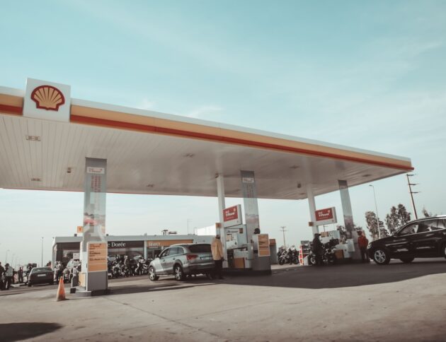 vehicles and people on Shell gasoline station during daytime
