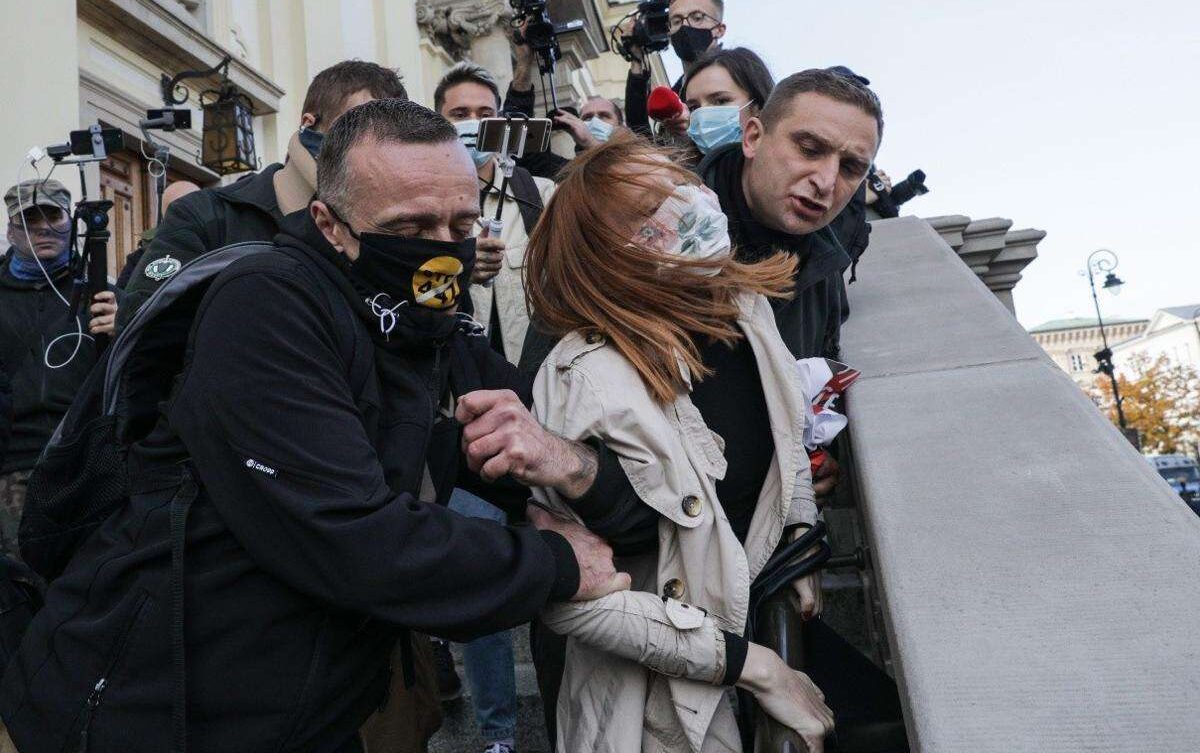  Ośrodek Monitorowania Zachowań Rasistowskich i Ksenofobicznych (OMZRiK), który wspiera oskarżycielkę:
„Podczas protestów w Warszawie Robert Bąkiewicz i jego bojówkarze siłą wynieśli kobietę z kościoła św. Krzyża, a następnie zrzucili ją ze schodów. Pani Angelika uderzyła głową o beton i straciła przytomność”.