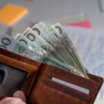 Brown leather wallet stuffed with polish currency.