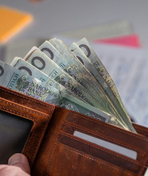 Brown leather wallet stuffed with polish currency.