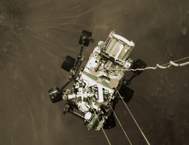 Zdjęcie łazika Perseverance z lądowania, zrobione od strony dźwigu-lądownika, Autorstwa NASA - https://mars.nasa.gov/resources/25609/high-resolution-still-image-of-perseverances-landing/, Domena publiczna