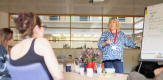 Szkolenie po godzinach? Sprawdź, kto za to płaci i czy należy ci się nadgodzinowe wynagrodzenie a woman explaining something to a group of people