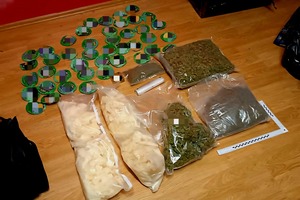 Zabezpieczone przez policję narkotyki: marihuana, MDMA, metamfetamina, kokaina i gotówka ujawnione podczas przeszukania.