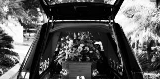 ZUS podnosi zasiłek pogrzebowy do 7000 zł od 2026 roku czarno-bałe zdjęcie z pogrzebu - auto z trumną w środku/ fot:/Unsplash